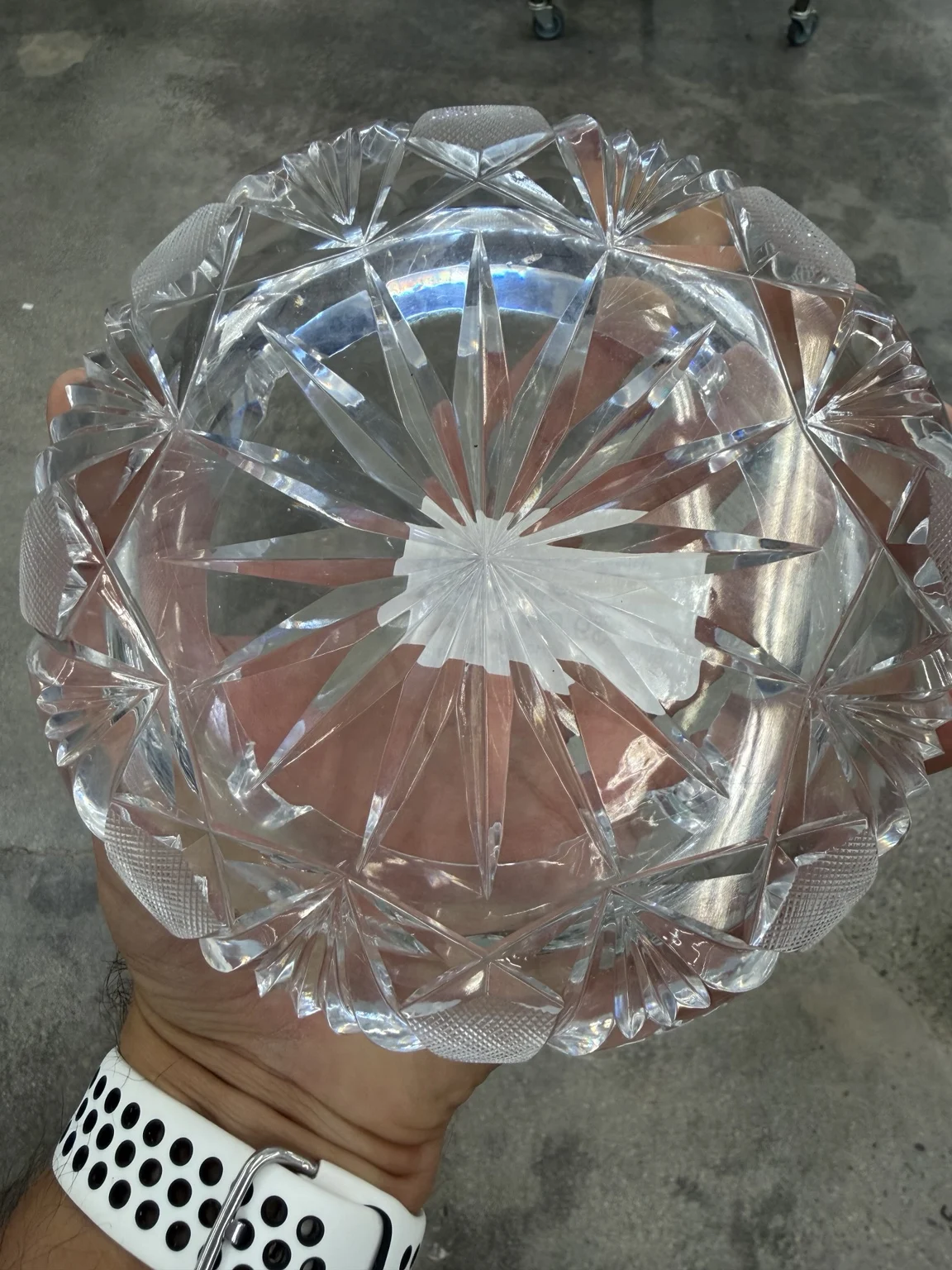The underside of the ashtray reveals a large cut starburst and a thick patterned rim.