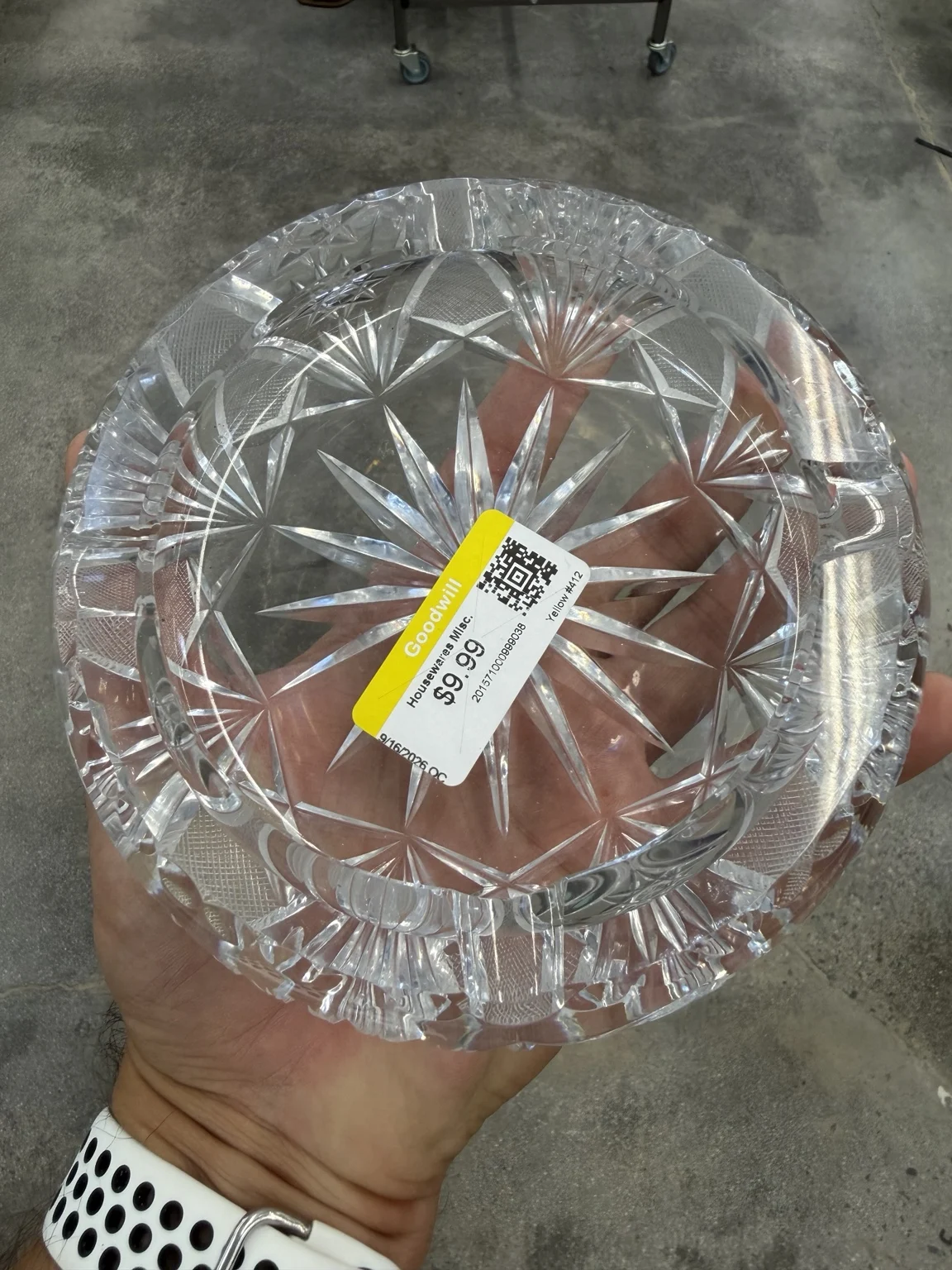 Angled top view of the ashtray with its $9.99 Goodwill sticker, geometric cuts and broad cigarette rests.
